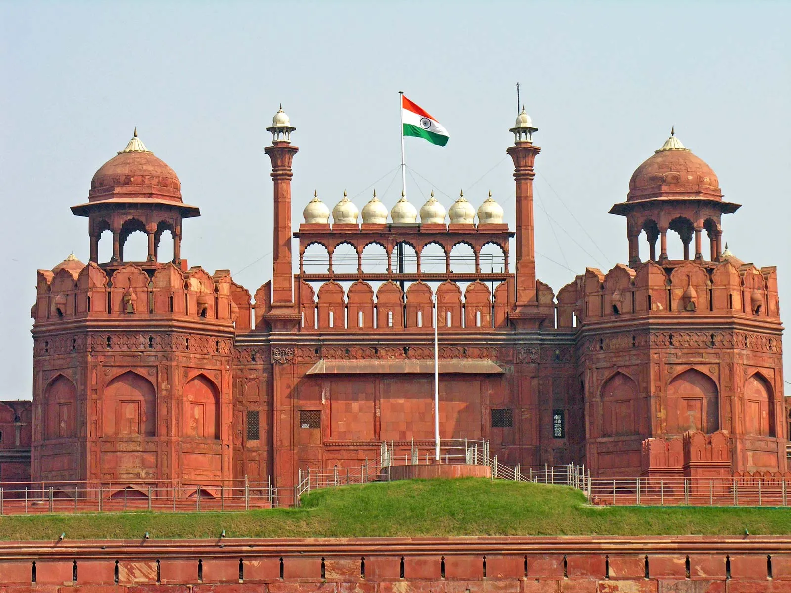 Forte Vermelho (Red Fort) em Delhi, com fachada de arenito vermelho e cúpulas douradas sob a bandeira da Índia